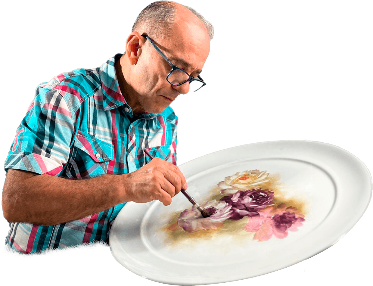 Felipe painting a porcelain plate.